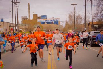Community running event showcasing diverse participants in energetic urban race for fitness and wellness.